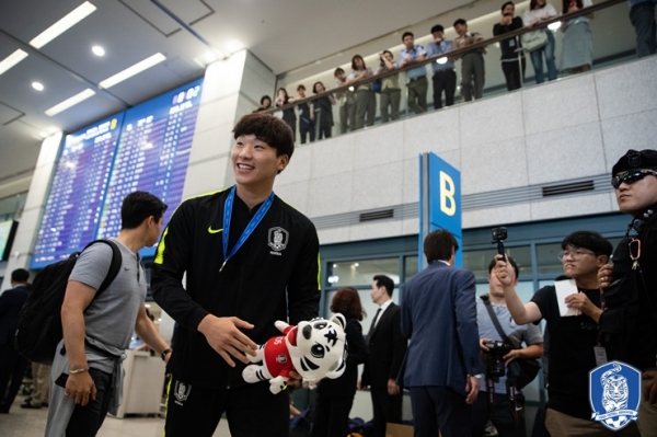 인천국제공항 입국장에 들어선 골키퍼 이광연 선수가 팬들을 보며 환하게 웃고 있다(사진: 대한축구협회 제공).