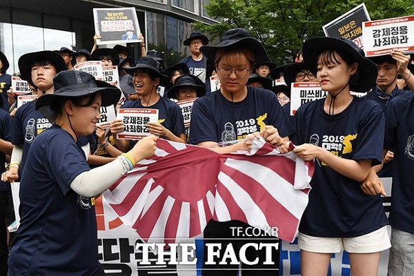 한국대학생진보연합의 미쓰비시 규탄집회가 지난 8월7일 오전 서울 중구 미씨비시 본사 앞에서 열린 가운데 참가자들이 전범기를 찢는 모습(사진 : 더 팩트 제공).