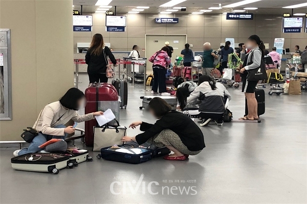 김해국제공항 2층 바닥에서 짐 정리하는 승객들(사진: 취재기자 김하은).