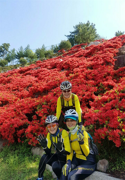 경남 김해 가야대 인근 꽃밭에서 자전거 라이딩 중 세 자매가 해맑게 웃고 있다(사진: 김영덕 씨 제공).