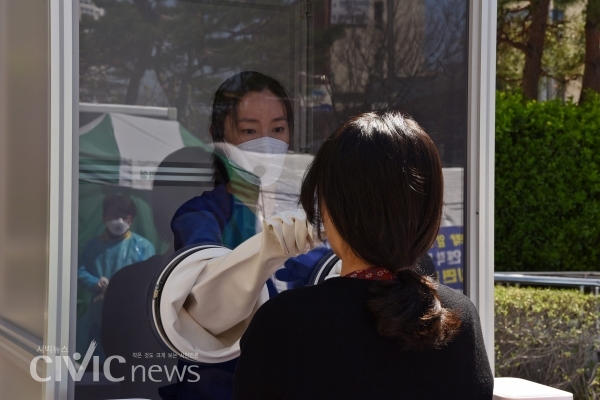 부산 남구보건소 안여현 의무사무관이 자신이 고안한 '워킹 스루 부스'에서 코로나 19 검사를 하고 있다(사진: 부산남구보건소 제공).