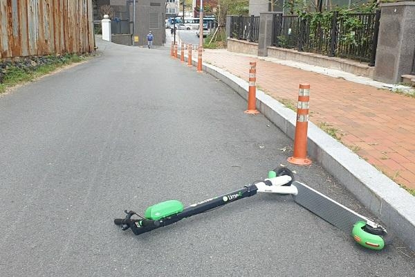 차 한 대만 지나갈 수 있는 좁은 골목길에 라임이 눕혀져 있어 자동차 통행을 방해하고 있다. 이런 경우 운전자는 차에서 내려 킥보드를 직접 옮겨야 한다(사진: 취재기자 조라희).