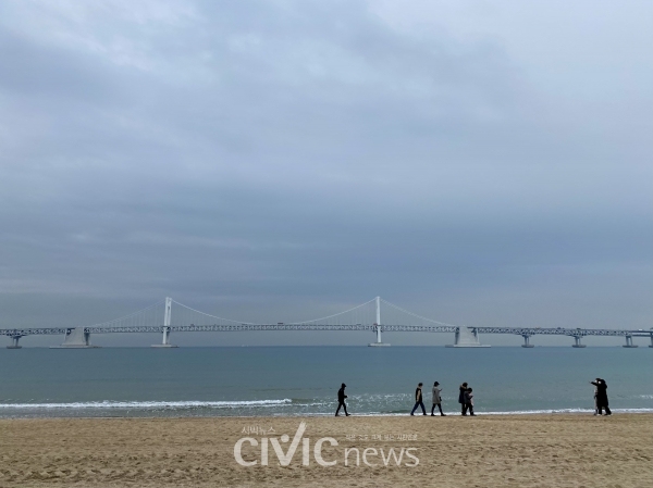 12월 29일 광안리 해수욕장에서 사람들이 바닷바람을 쐬고 있다. 부산시는 연말연시 특별방역 강화조치로 12월 31일부터 1월 1일 오전 9시까지 광안리 해수욕장을 비롯한 부산시 내 해수욕장 7곳을 폐쇄 조치한다고 발표했다(사진: 취재기자 김수빈).