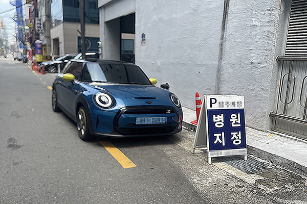 사하구 하단동 내 위치한 주차타워 측에서 세워둔 팻말과 차량이 바로 옆 아파트 앞에 주차되어 있다(사진: 취재기자 최진홍).